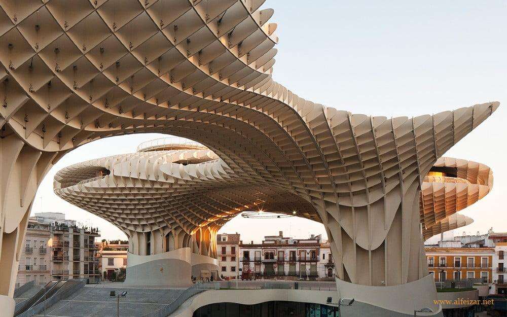 Metropol Parasol, conocido popularmente como Setas de Sevilla,2 es una estructura en forma de pérgola de madera y hormigón ubicada en la céntrica plaza de la Encarnación de la ciudad de Sevilla, en la comunidad autónoma de Andalucía (España). Cuenta con unas dimensiones de 150 metros de largo, 70 metros de ancho y una altura aproximada de 26 metros. Su base alberga un mercado tradicional3 y locales de restauración en la planta baja, una plaza de espectáculos y el museo arqueológico Antiquarium. La estructura se corona con una terraza y un mirador que ofrece una vista panorámica del casco antiguo de la ciudad.